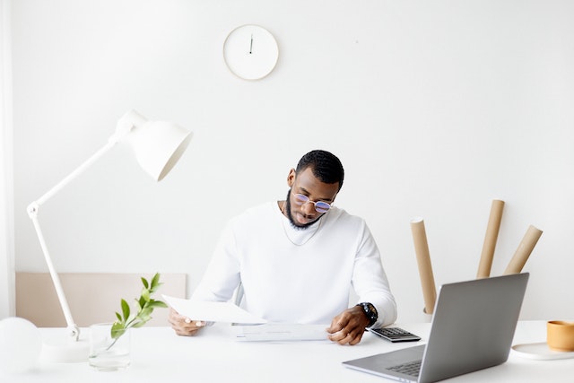 A man reading some documents on his desk.