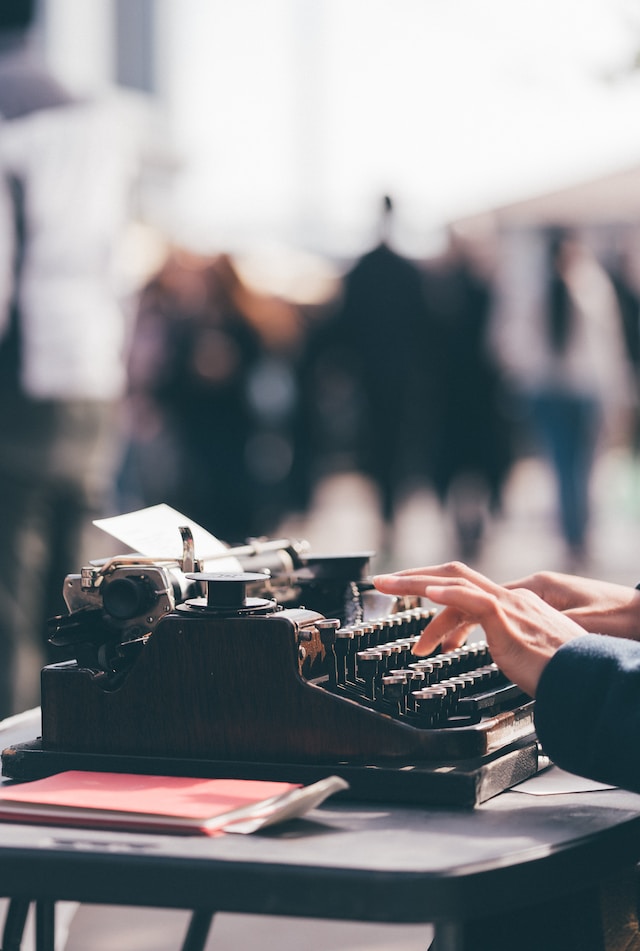 A hand tapping the keys of a typewriter.