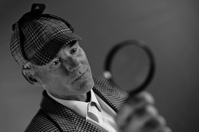 A dapper gentleman holding a magnifying glass