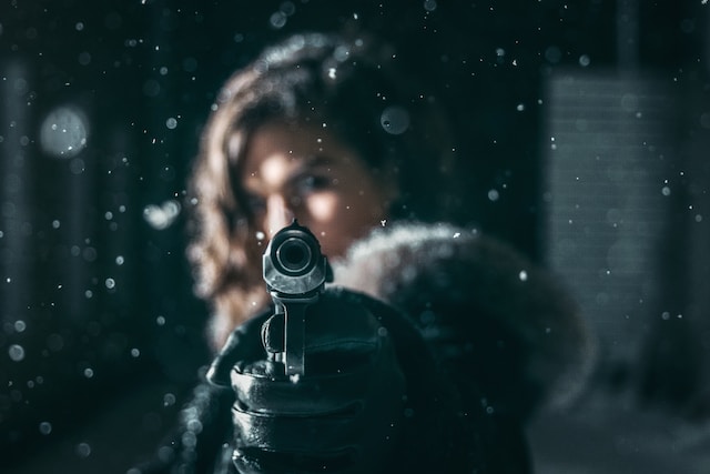 A woman aiming a gun