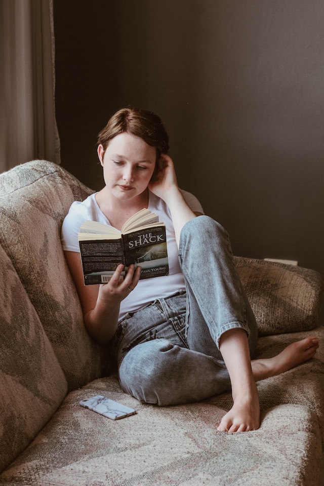 Woman sitting on the couch and reading a book