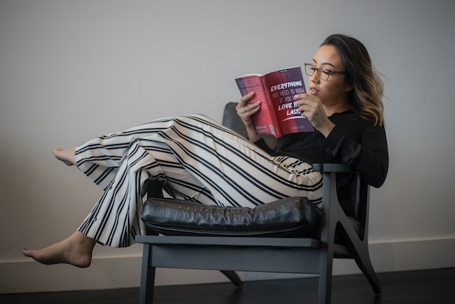 Woman lounging on a chair and reading a book