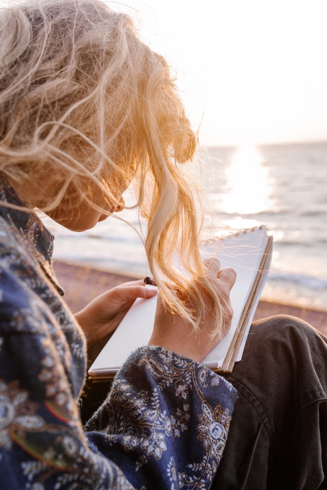 Woman with a notepad and pen on the beach