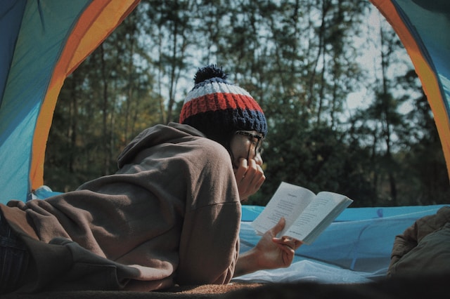 Girl reading a book inside a tent