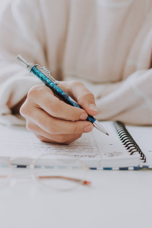 A person writing on a notebook