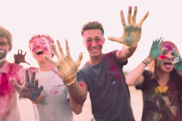 A group of teens covered in paint colors