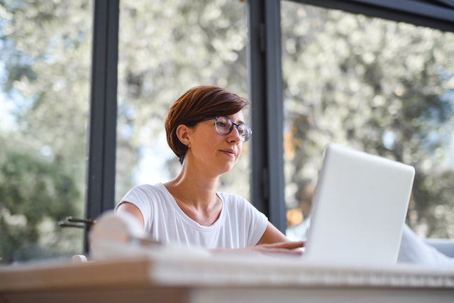 Woman in white shirt working from home