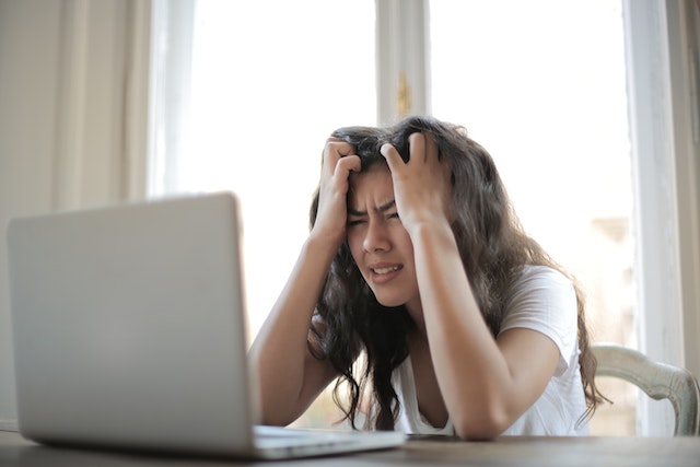 Frustrated woman staring at an open laptop