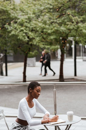 Woman sitting outside a coffeeshop 