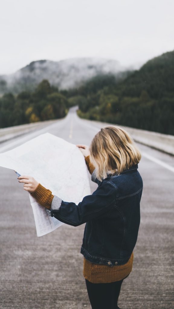 Girl in the middle of the road looking at a map